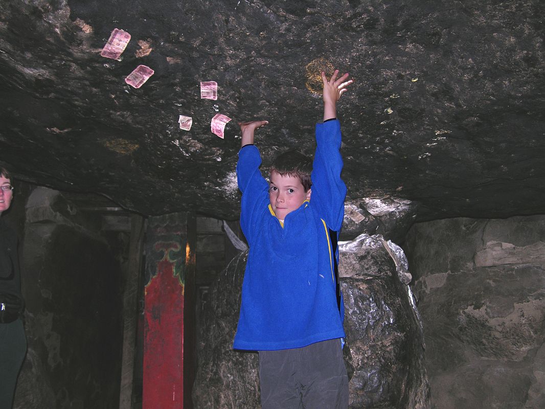 04 Peter Ryan At Milarepa Cave Near Nyalam Peter Ryan does his best Milarepa imitation at the low-ceilinged Milarepa Cave in 2005. The cave is formed by a large overhang supported by a smaller rock. Milarepa supposedly used his magic feats by raising the ceiling of the cave with his bare hands while Rechungpa slid in the other piece. You can still see his handprints in the roof.